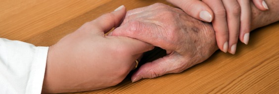 Yngre hænder holder om ældre hånd